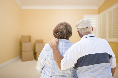 Hugging,Senior,Couple,In,Room,Looking,At,Moving,Boxes,On seniors looking at a decluttered room with boxes prepared for donations